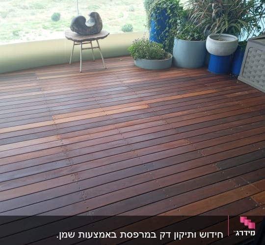 רצפת עץ עם עציצים על מרפסת